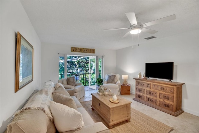 tiled living room featuring ceiling fan and a textured ceiling