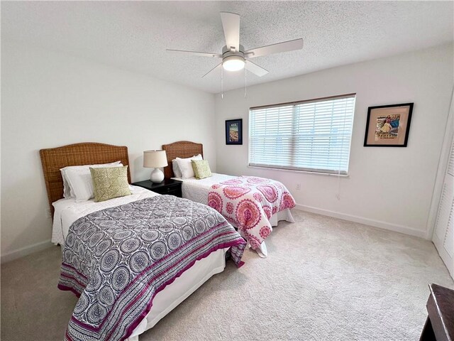 carpeted bedroom featuring a textured ceiling and ceiling fan