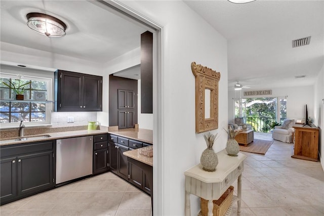 kitchen featuring backsplash, ceiling fan, sink, light tile patterned floors, and dishwasher