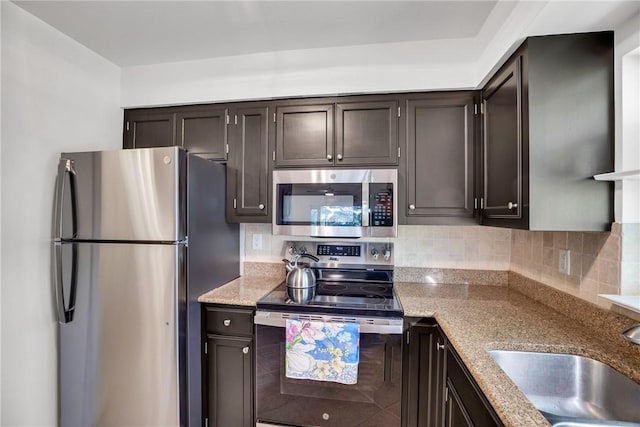 kitchen featuring tasteful backsplash, sink, stainless steel appliances, and dark brown cabinets