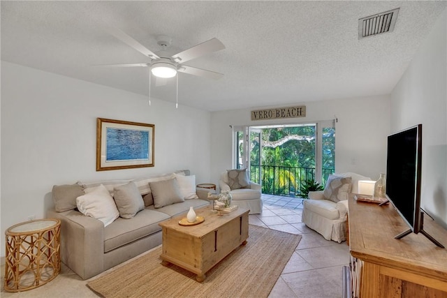 tiled living room featuring ceiling fan and a textured ceiling