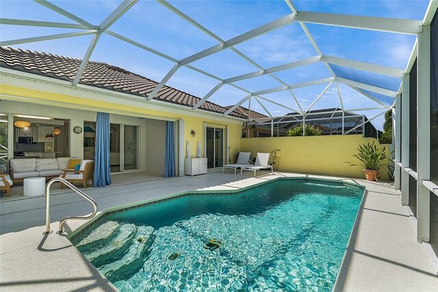 outdoor pool with a patio area and outdoor lounge area
