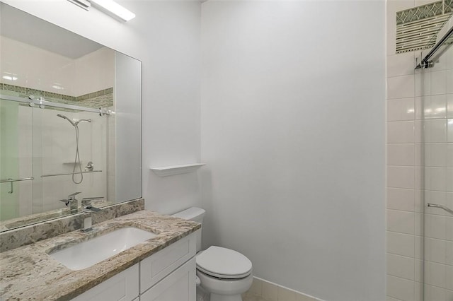 bathroom with toilet, a shower stall, and vanity