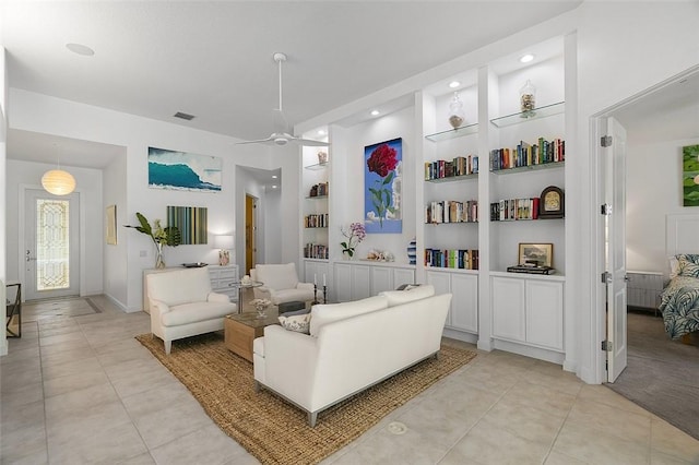 living area with light tile patterned floors, built in shelves, baseboards, ceiling fan, and recessed lighting