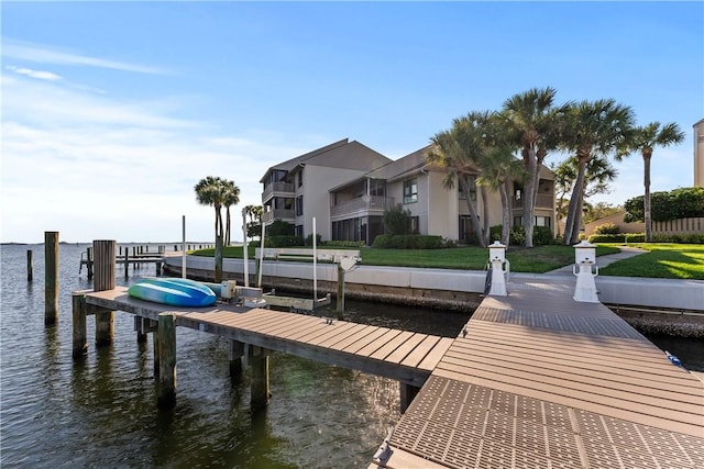 view of dock featuring a water view, a residential view, and boat lift