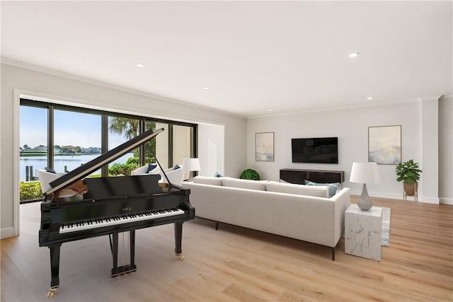 living room with ornamental molding, a water view, and light wood-type flooring