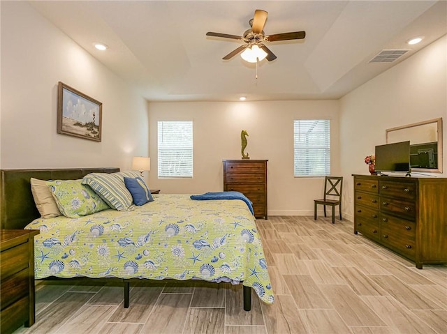 bedroom featuring ceiling fan, light hardwood / wood-style flooring, and multiple windows