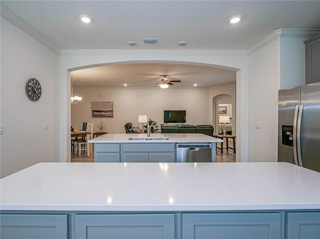 kitchen featuring a center island, sink, stainless steel appliances, crown molding, and ceiling fan with notable chandelier