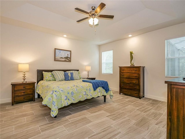 bedroom with a raised ceiling and ceiling fan