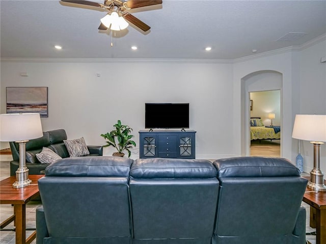 living room featuring hardwood / wood-style flooring, ceiling fan, and ornamental molding