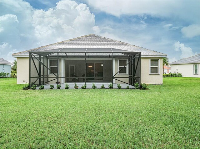 rear view of property featuring a yard and a lanai