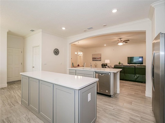 kitchen featuring sink, hanging light fixtures, gray cabinets, a kitchen island, and stainless steel appliances