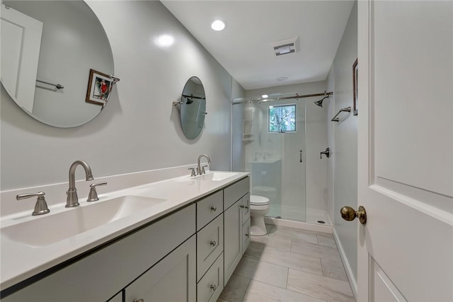 bathroom featuring vanity, a shower with shower door, tile patterned floors, and toilet