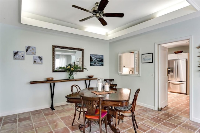 dining space featuring a tray ceiling and ceiling fan