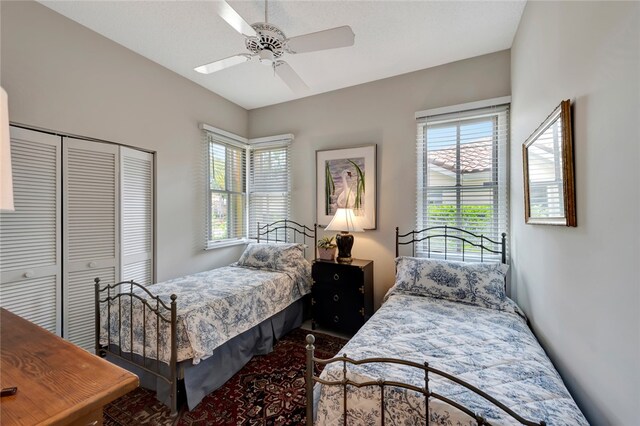 bedroom featuring ceiling fan, multiple windows, and a closet