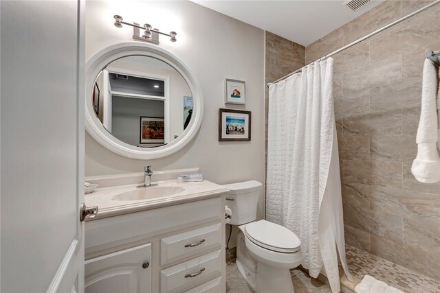 bathroom featuring walk in shower, vanity, and toilet