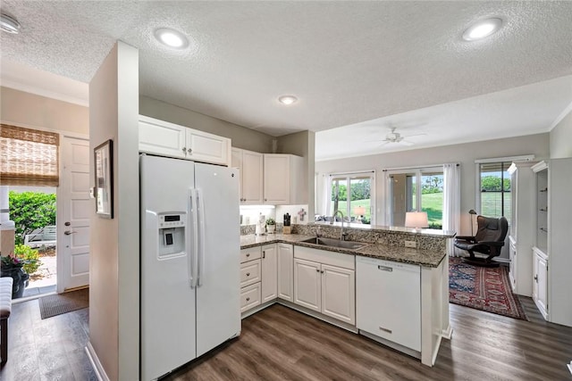4851 N Newport Island Dr Unit 12A, Vero Beach, FL 32967 - kitchen with white appliances, a sink, a peninsula, a textured ceiling, and dark wood-style floors