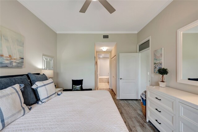 bedroom with ornamental molding, light hardwood / wood-style floors, ceiling fan, and ensuite bathroom