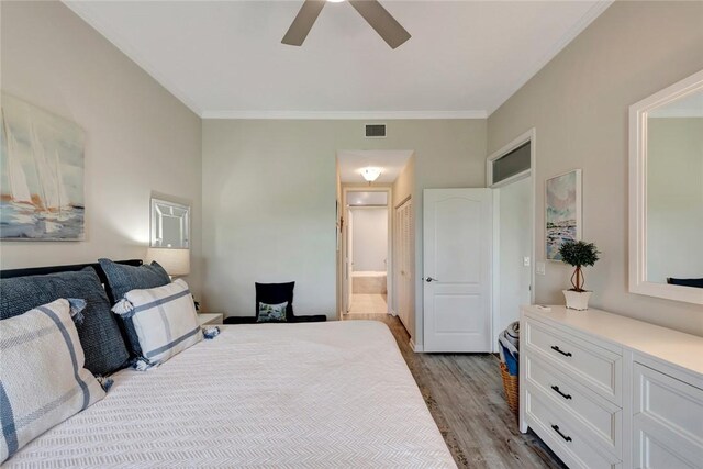 4851 N Newport Island Dr Unit 12A, Vero Beach, FL 32967 - bedroom featuring wood finished floors, crown molding, ensuite bathroom, and a ceiling fan