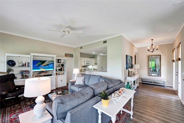 living room featuring hardwood / wood-style flooring, ceiling fan with notable chandelier, and ornamental molding