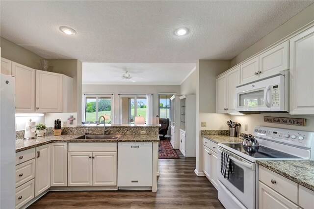 kitchen featuring stone countertops, white appliances, sink, and white cabinets