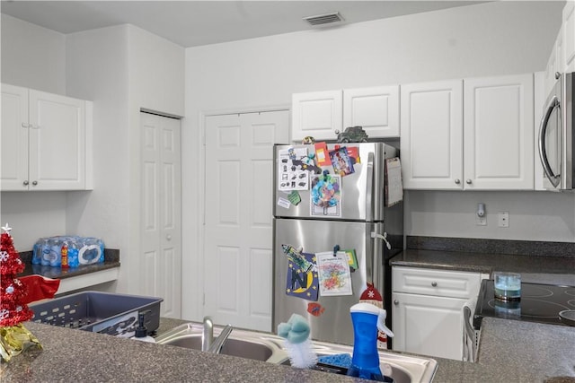 kitchen with white cabinets and appliances with stainless steel finishes