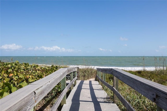 view of community with a water view and a beach view
