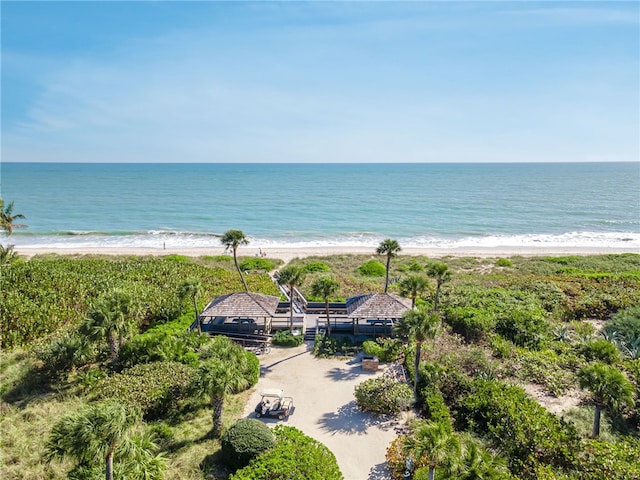 property view of water featuring a dock and a beach view