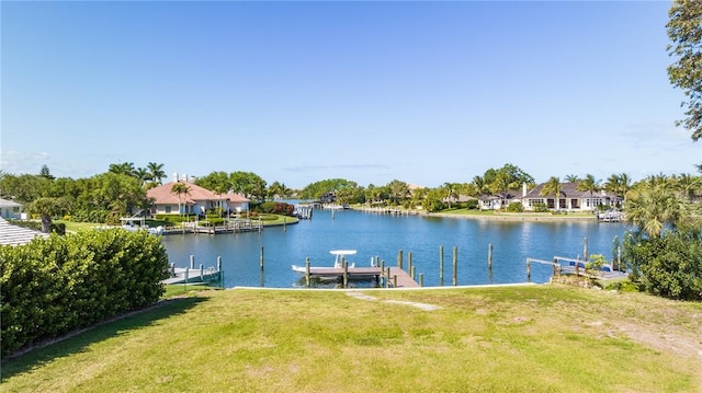 view of dock featuring a water view, a residential view, a lawn, and boat lift