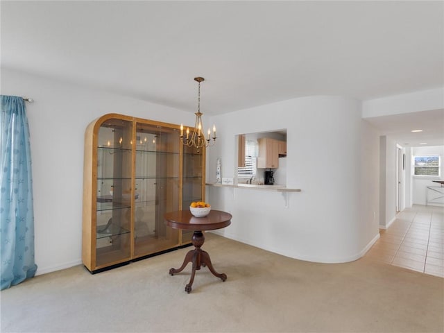 dining space with light colored carpet and a notable chandelier