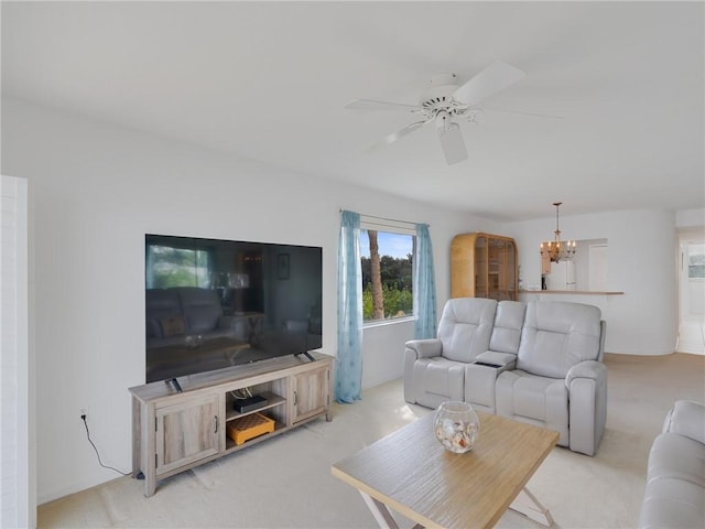 carpeted living room featuring ceiling fan with notable chandelier