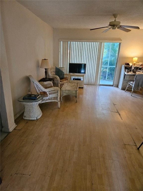 living area featuring light hardwood / wood-style floors and ceiling fan