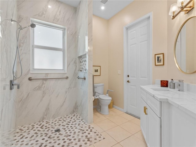 bathroom featuring tile patterned floors, toilet, vanity, and tiled shower