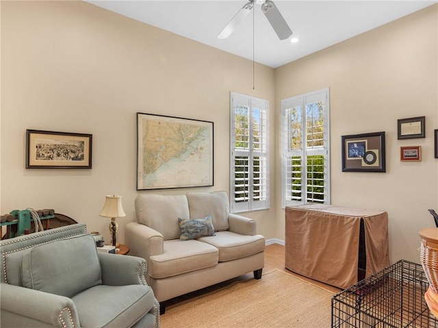 living room featuring ceiling fan and light hardwood / wood-style floors