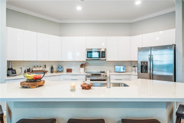 kitchen featuring white cabinetry, sink, a kitchen bar, and stainless steel appliances