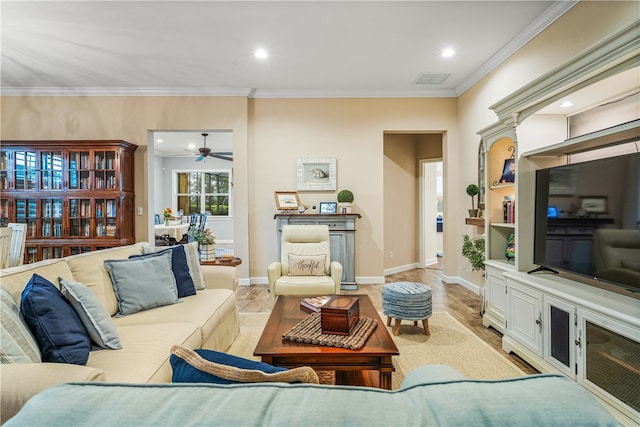 living room featuring light hardwood / wood-style flooring, ceiling fan, and crown molding