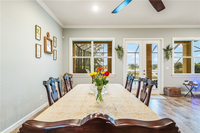 dining space with hardwood / wood-style flooring, plenty of natural light, french doors, and crown molding