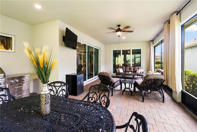 sunroom / solarium featuring ceiling fan