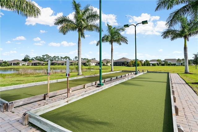 view of property's community with a water view and a lawn