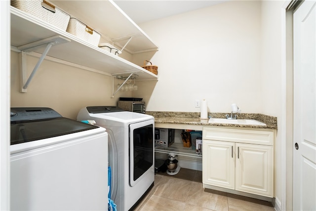 washroom featuring light tile patterned floors, washing machine and dryer, cabinets, and sink