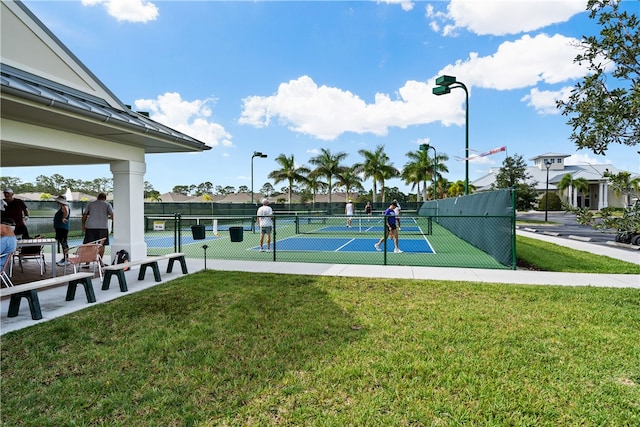 view of tennis court featuring a yard