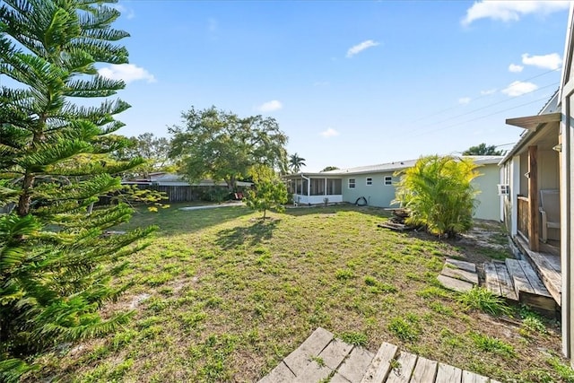 view of yard featuring a sunroom and fence