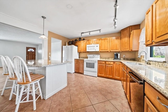 kitchen with white appliances, a healthy amount of sunlight, a sink, and light tile patterned floors