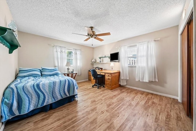 bedroom featuring light wood-style floors, a closet, ceiling fan, and baseboards