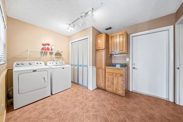 laundry room with visible vents, light tile patterned flooring, a textured ceiling, track lighting, and washer and dryer