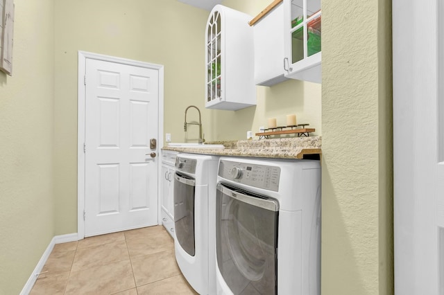 washroom with washer and clothes dryer, cabinets, sink, and light tile patterned floors