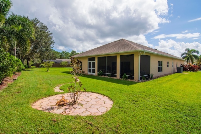 back of house with a sunroom, a yard, and cooling unit