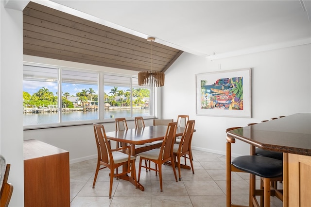 dining room with a water view, light tile patterned floors, and lofted ceiling