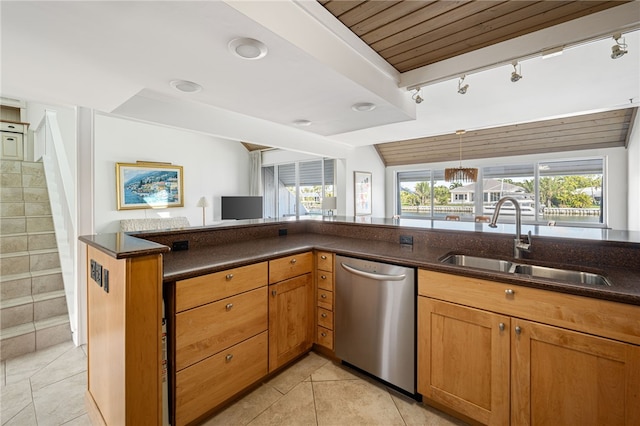 kitchen with light tile patterned flooring, sink, vaulted ceiling, dark stone countertops, and dishwasher