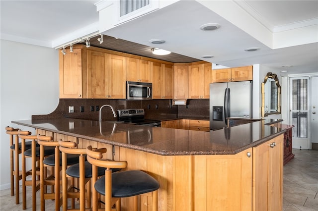 kitchen with ornamental molding, stainless steel appliances, kitchen peninsula, and backsplash